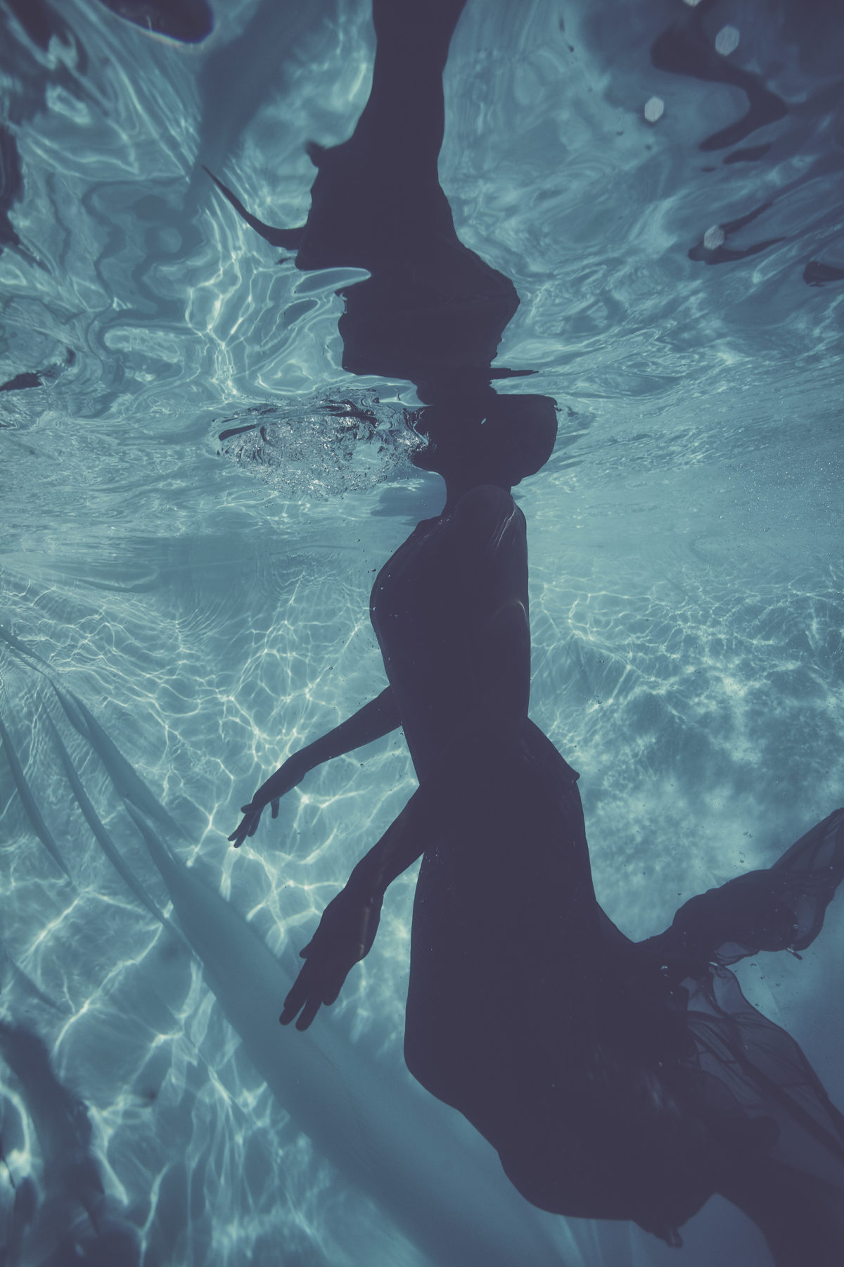 A woman in a gown underwater