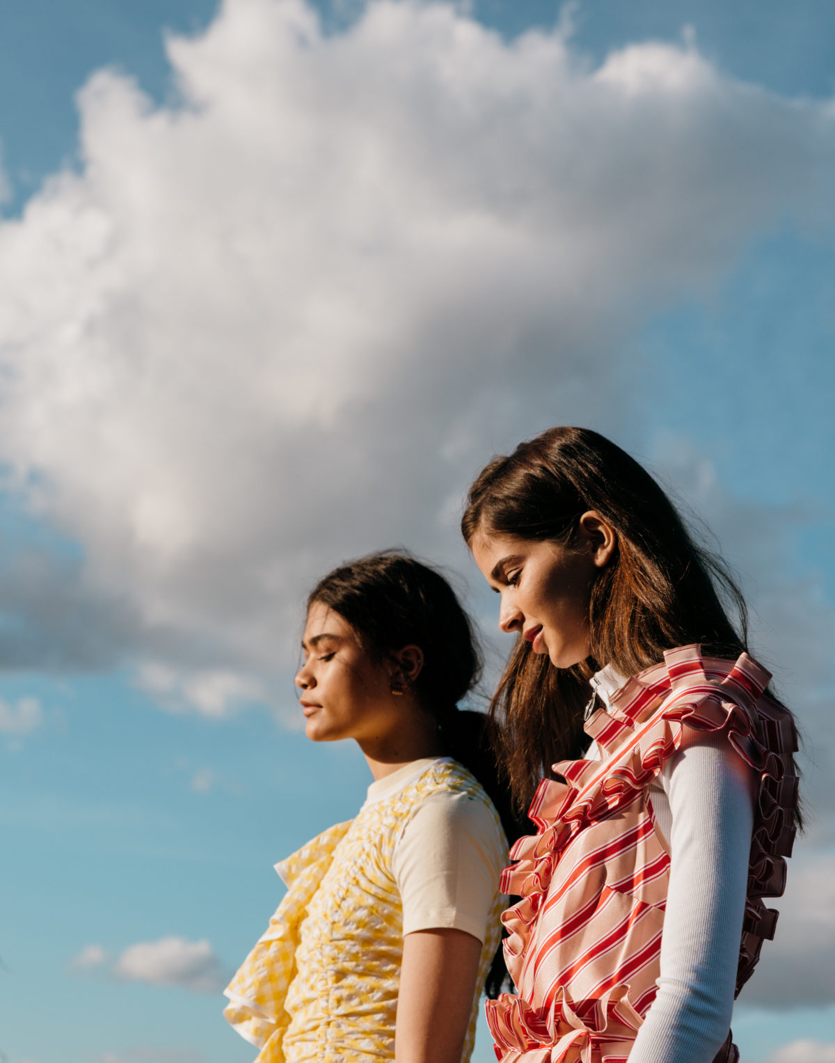 An upclose photo of two women dressed in high fashion outdoors