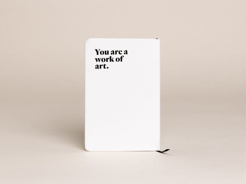 The back of a Darling journal that says, "You are a work of art."