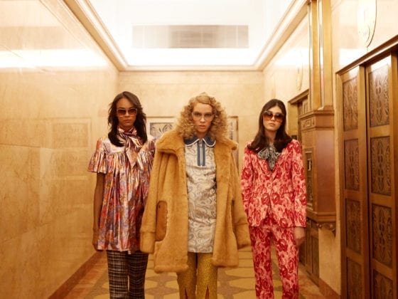 Three women walking down a hallway in 70's high fashion