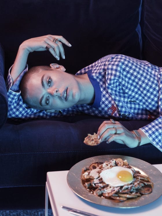 A woman leaning over with a small table in front of her with a plate of eggs