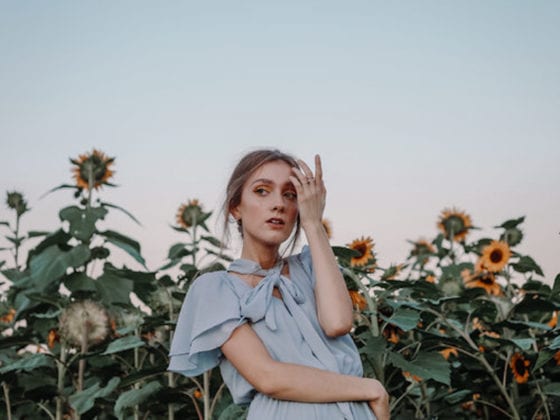 A picture of a girl in a dress in a field of sunflowers