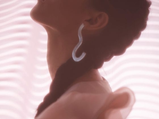 A side profile of a woman with her head titled back and her eyes closed