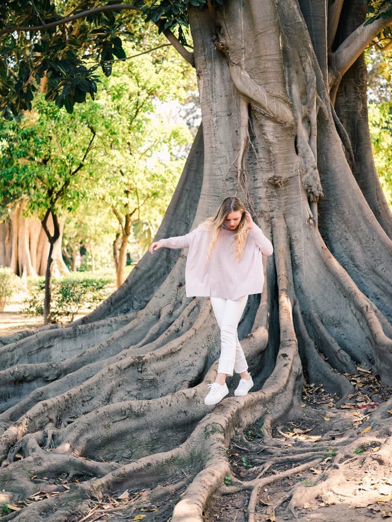 A woman tiptoeing on the roots of a tree