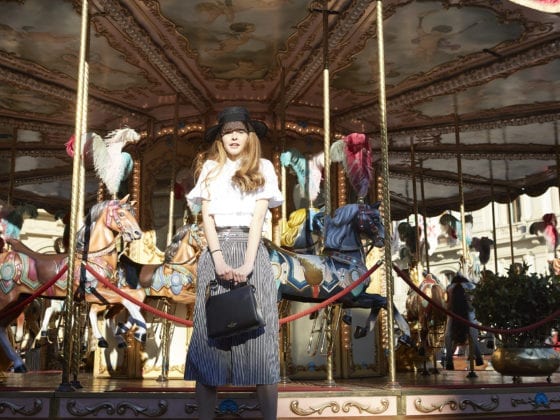 A woman standing in front of a carousel