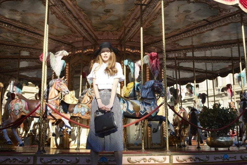 A woman standing in front of a carousel