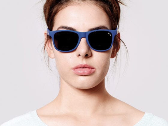 A woman with sunglasses and a top bun