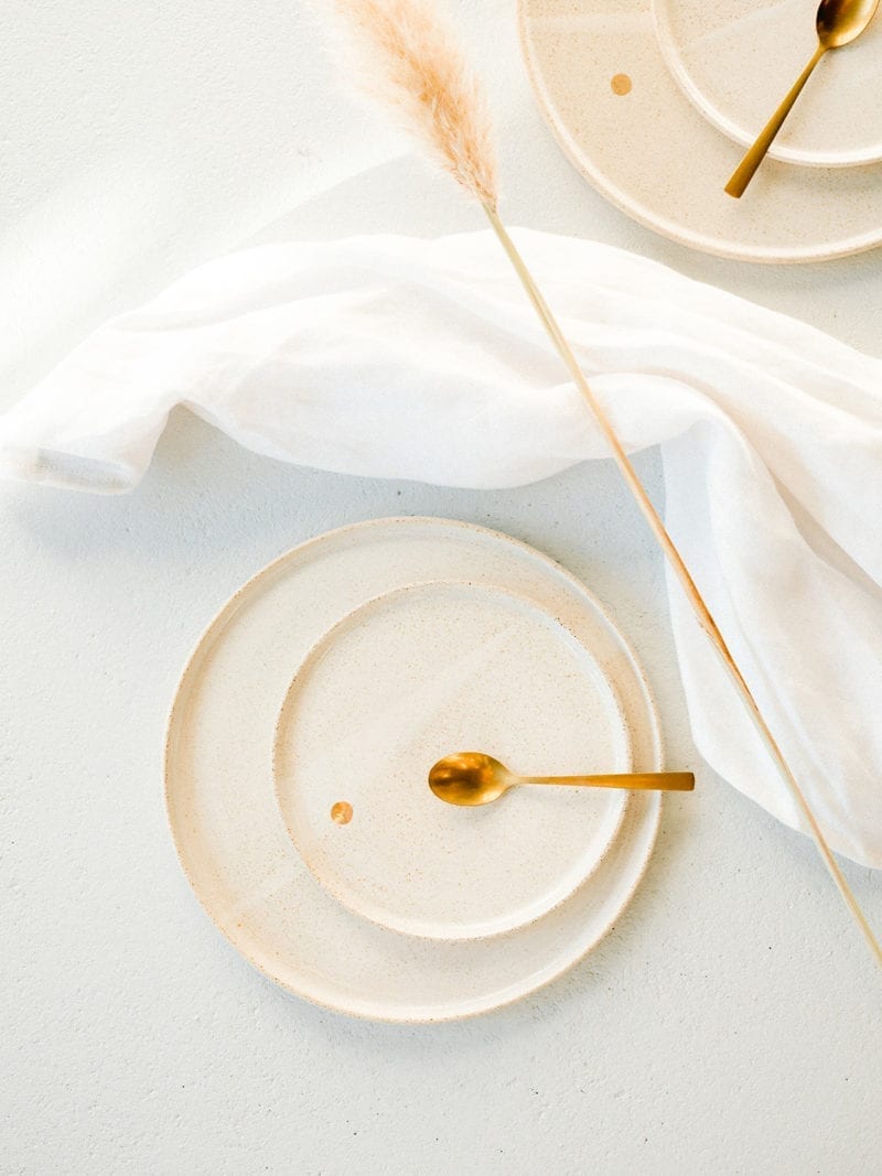An empty plate with a fig and a white towel on the table