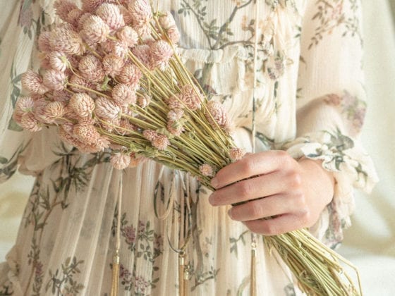 An unclose photo of a woman's hands holding flowers