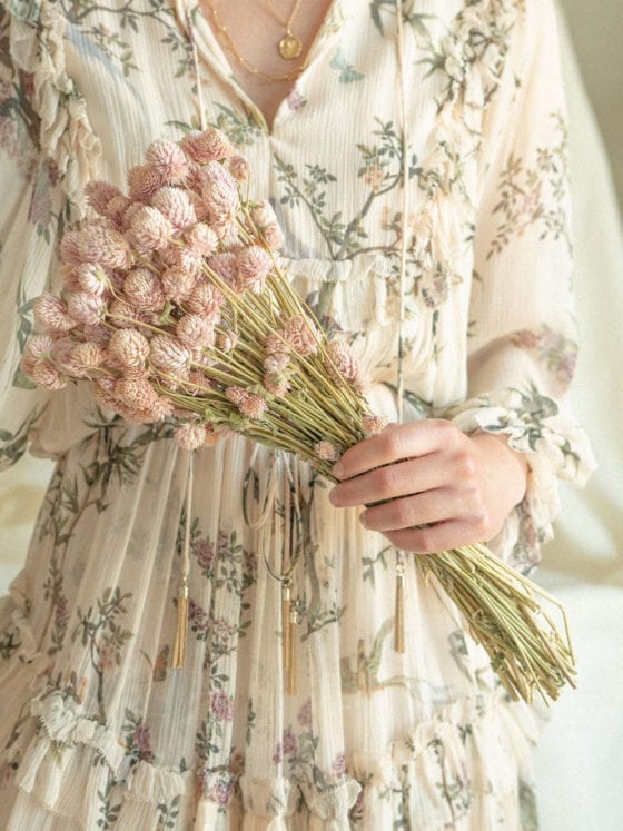 An unclose photo of a woman's hands holding flowers