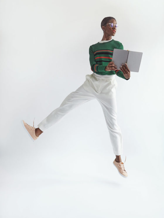 A woman reading a book as she jumps in the air