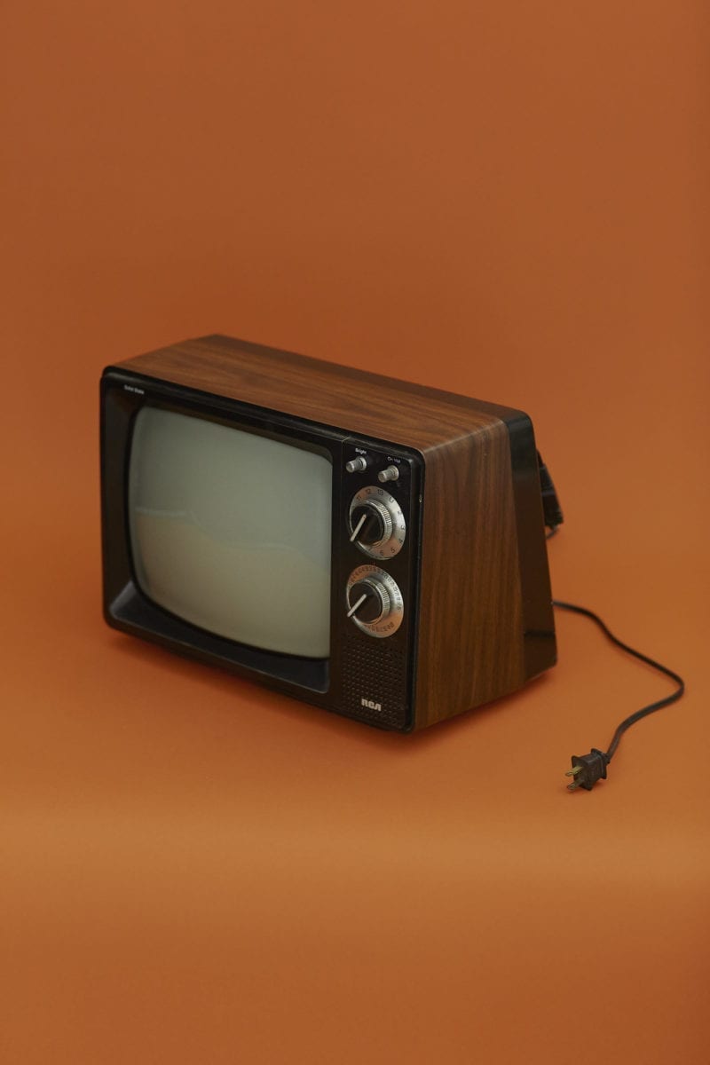A old TV with the cord stretched out on the table