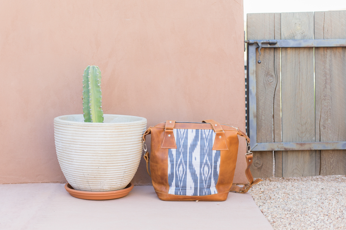 a purse on the ground by a cacti plant