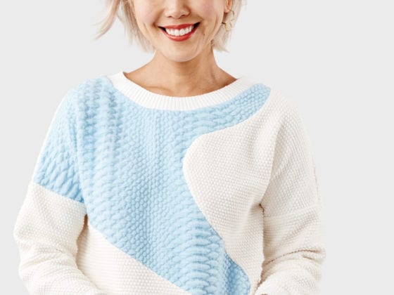 A woman in a blue and cream sweater