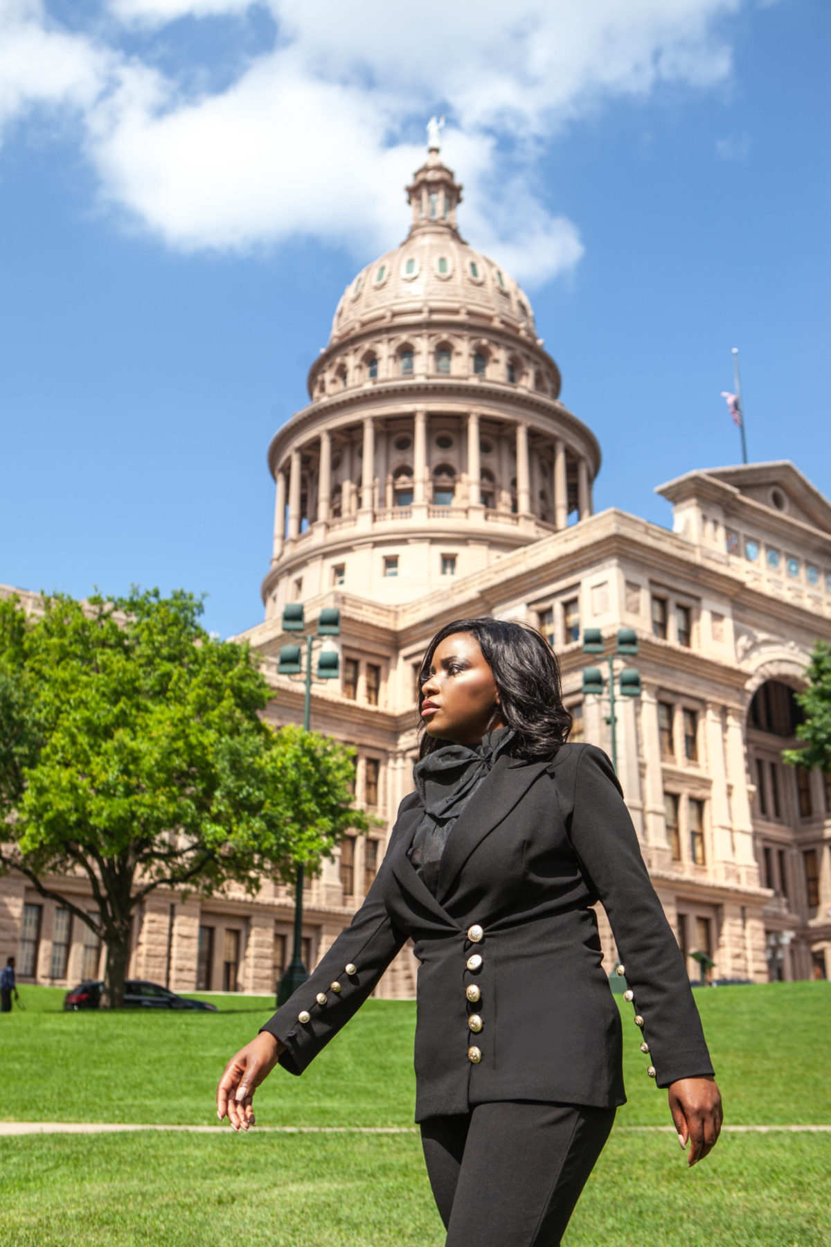 A woman in a suit walking past a government building