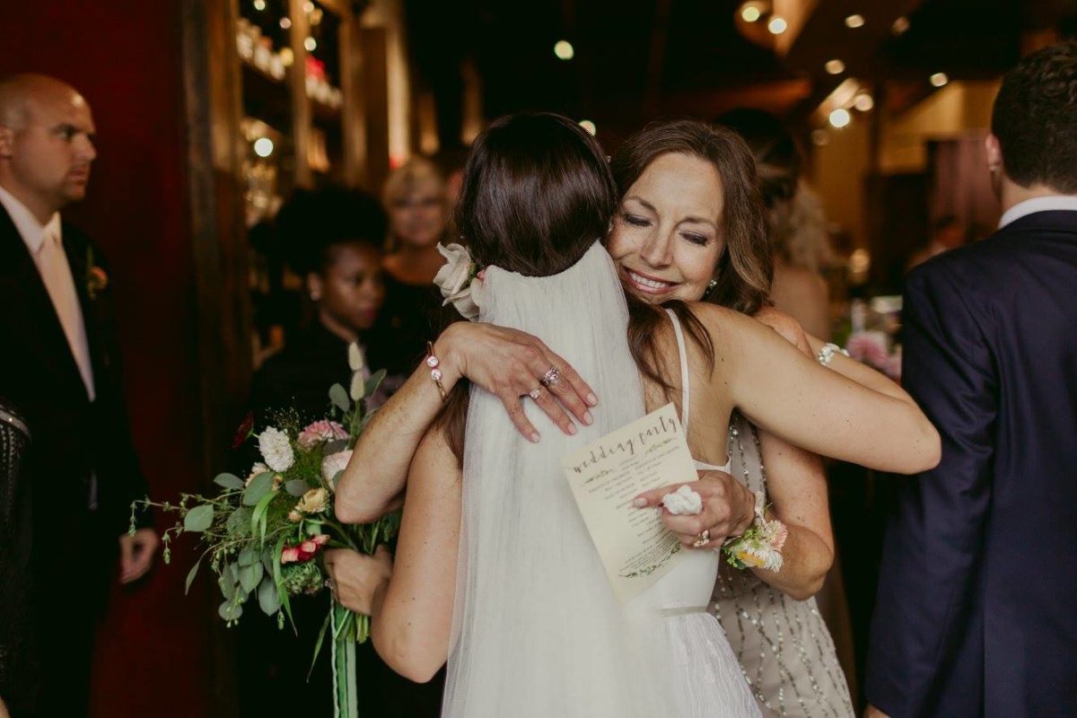 A woman hugging a bride on her wedding day