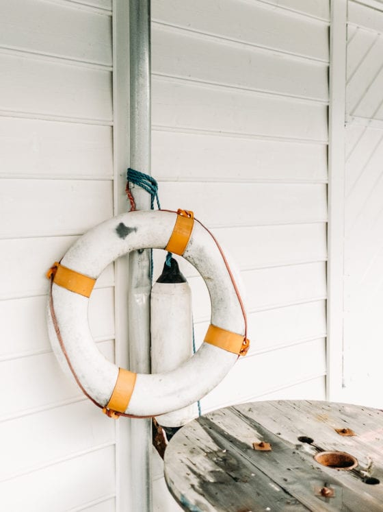 A picture of a life raft leaning on the side of a house