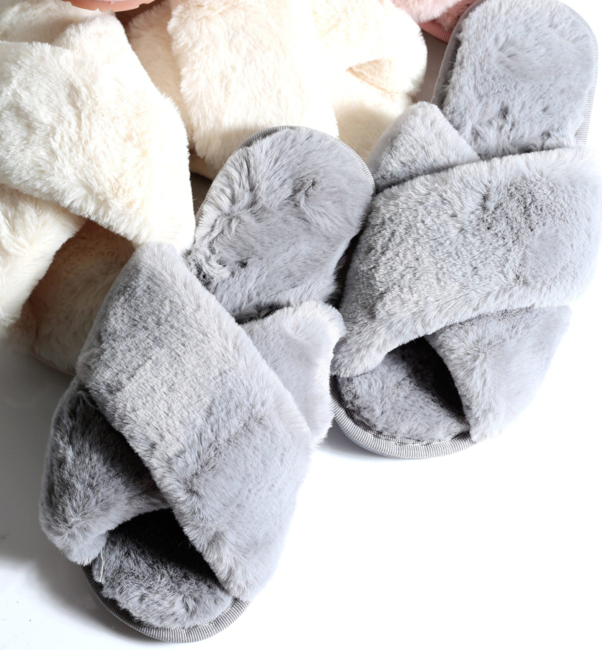 Two pairs of fluffy slippers in grey and cream