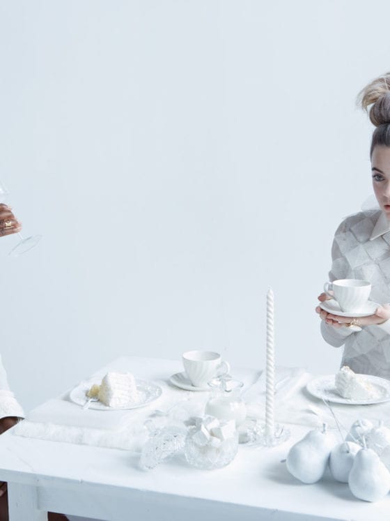 two women sitting at a snow themed table where everything is painted in white