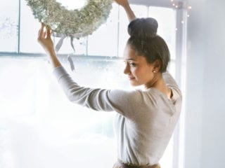 A woman hanging a wreath
