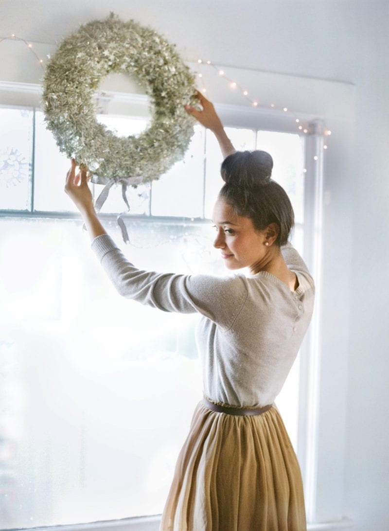A woman hanging a wreath