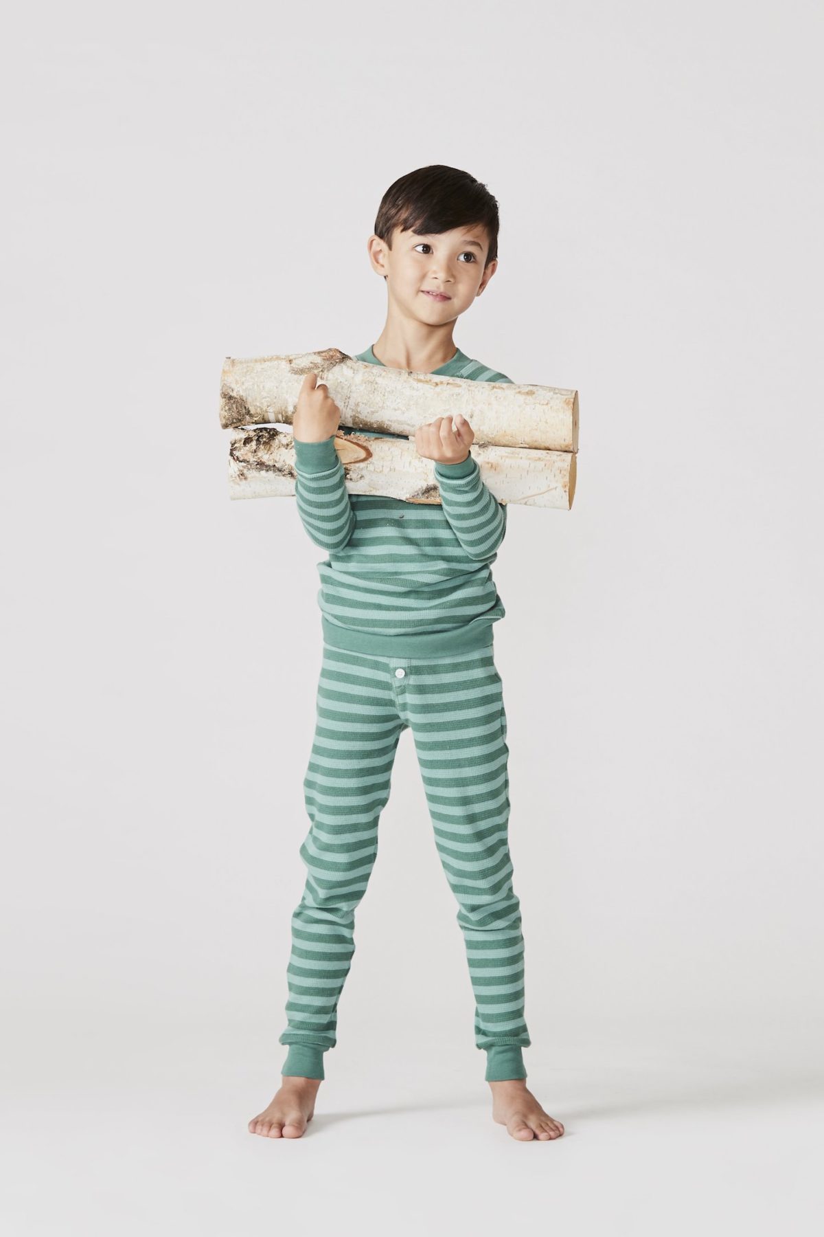 A picture of a boy in stripped green pajamas