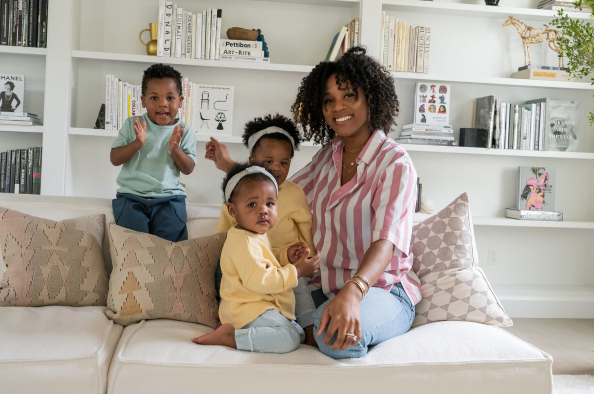 A mom sitting on a couch with her three kids