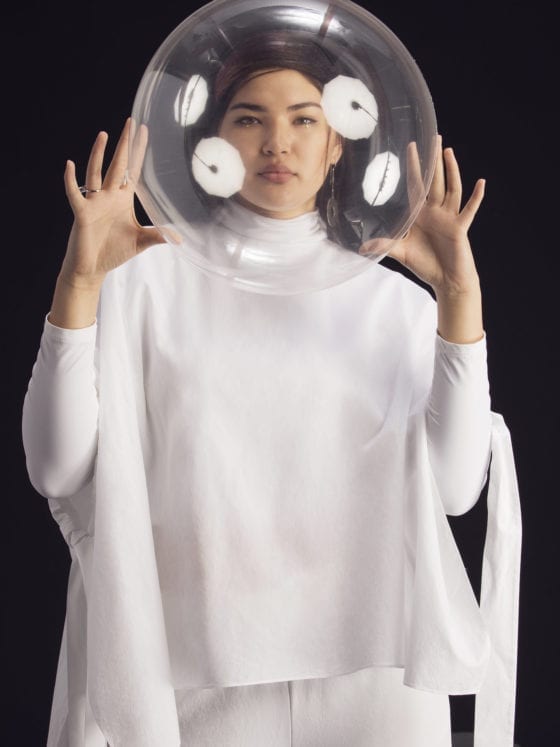 A woman with a clear ball around her head as if she were in space