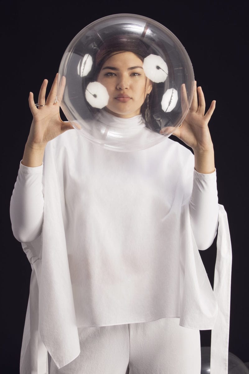 A woman with a clear ball around her head as if she were in space