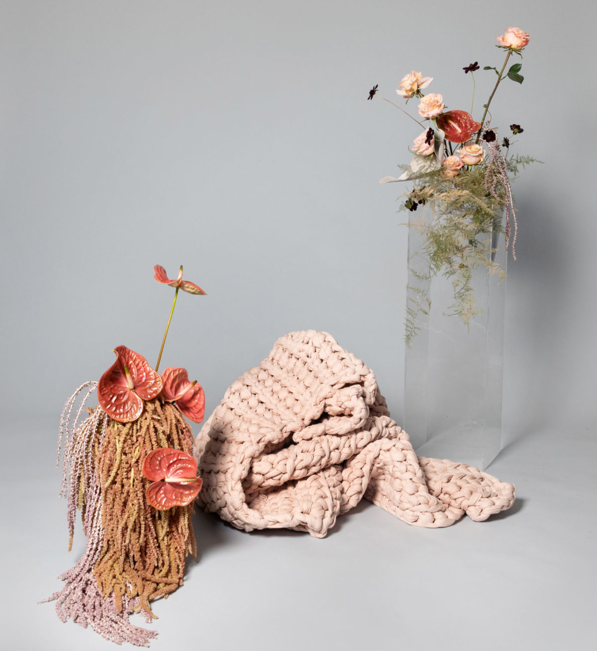 A blanket folded on the floor by flowers