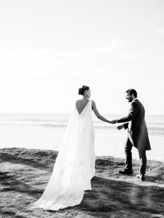 A couple walking along the beach on their wedding day