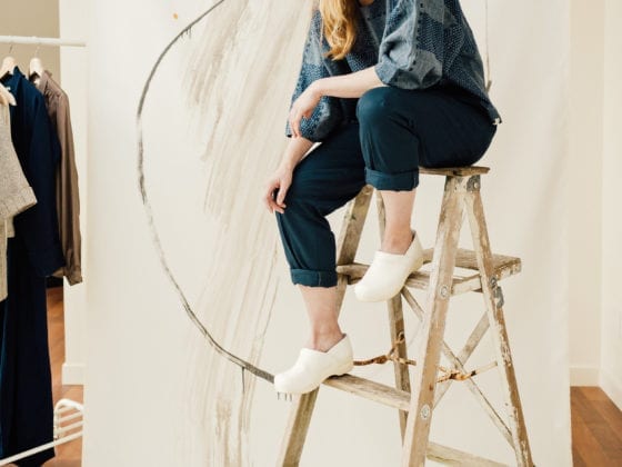 A woman seated atop of a ladder