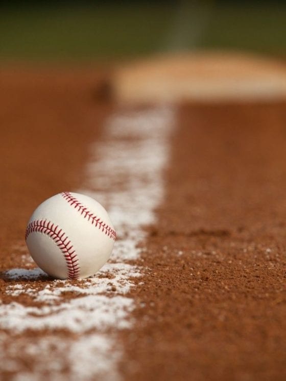 A close up of a baseball on an empty field