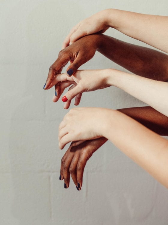 A pair of hands of people of different races intersecting
