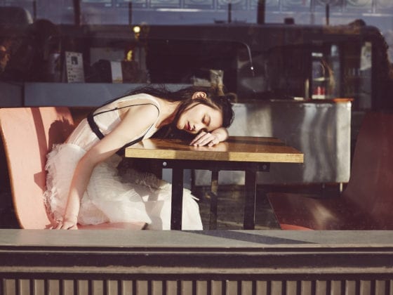 A woman with her head down on a diner table