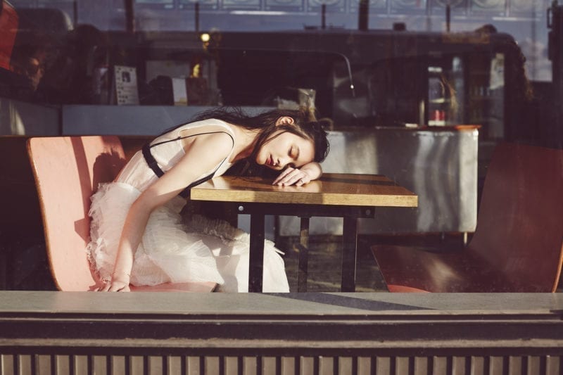A woman with her head down on a diner table