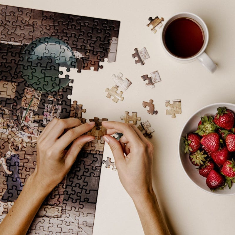 A woman's hands as she puts together a puzzle